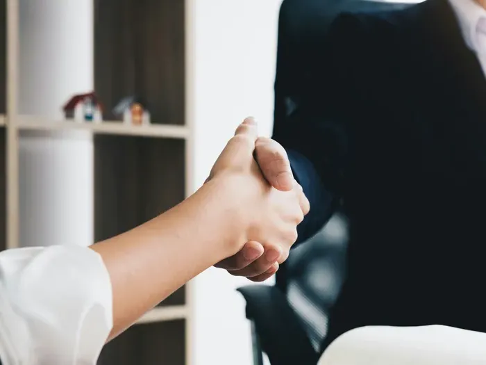 Close-up handshake between professionals, highlighting business listings, dofollow backlinks, and customer trust